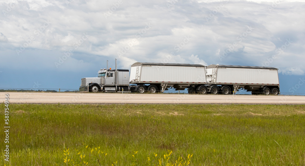 A highway truck hauling freight along a highway. Taken in Alberta, Canada A highway truck hauling freight along a highway. Taken in Alberta, Canada