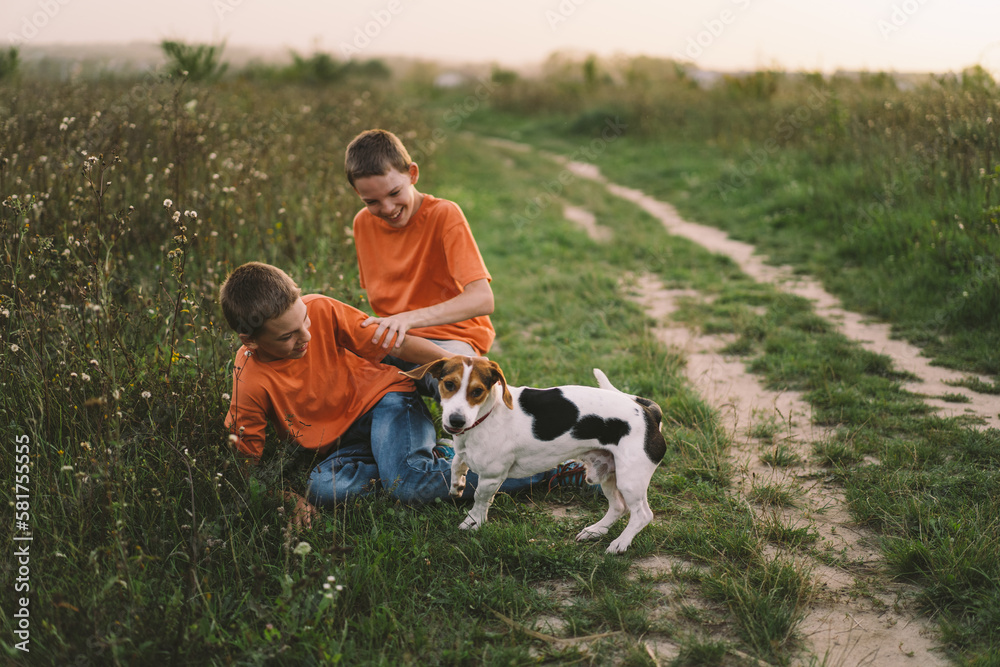 Funny twin brother boys in orange t-shirt playing outdoors on field at sunset. Happy children, lifestyle. Funny twin brother boys in orange t-shirt playing outdoors on field at sunset. Happy children, lifestyle.