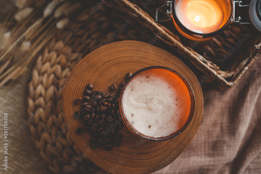 Body scrub of ground coffee, sugar and coconut oil in glass jar on white rustic table, homemade cosmetic for peeling and spa care, top view Body scrub of ground coffee, sugar and coconut oil in glass jar on white rustic table, homemade cosmetic for peeling and spa care, top view