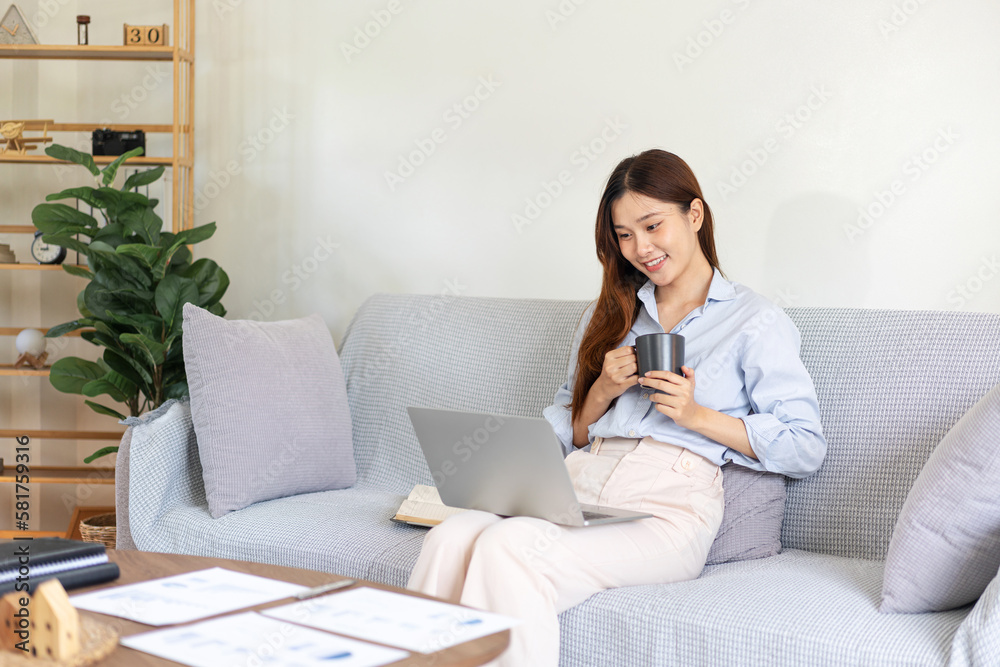Female freelance is reading business data on laptop and writing Female freelance is reading business data on laptop and writing