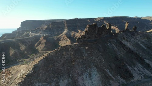 Aerial shot in orbit over a rock formation called El Camello and close to Medio Almud beach on the island of Gran Canaria and on a sunny day. photo