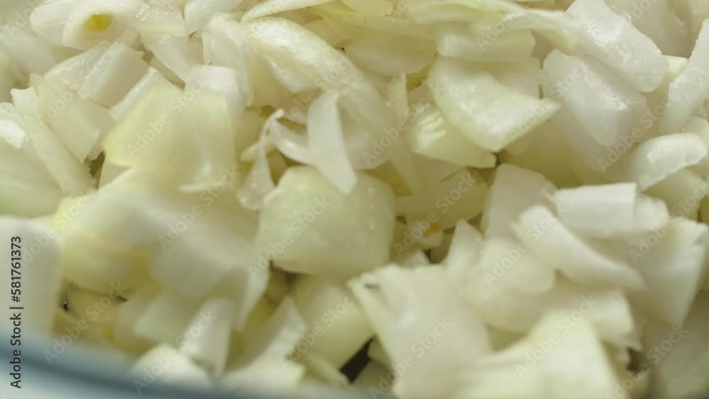 Super close-up of the white onion cubes falling in the glass tray Super close-up of the white onion cubes falling in the glass tray