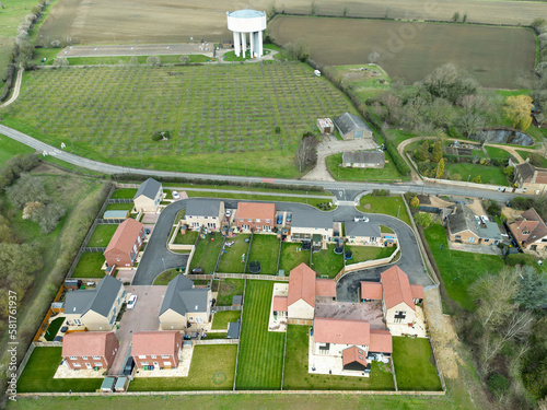 Drone view of a brownfield housing development on the edge of an East Anglian village. A water tower in the distant supplies water to the sprawling village. photo