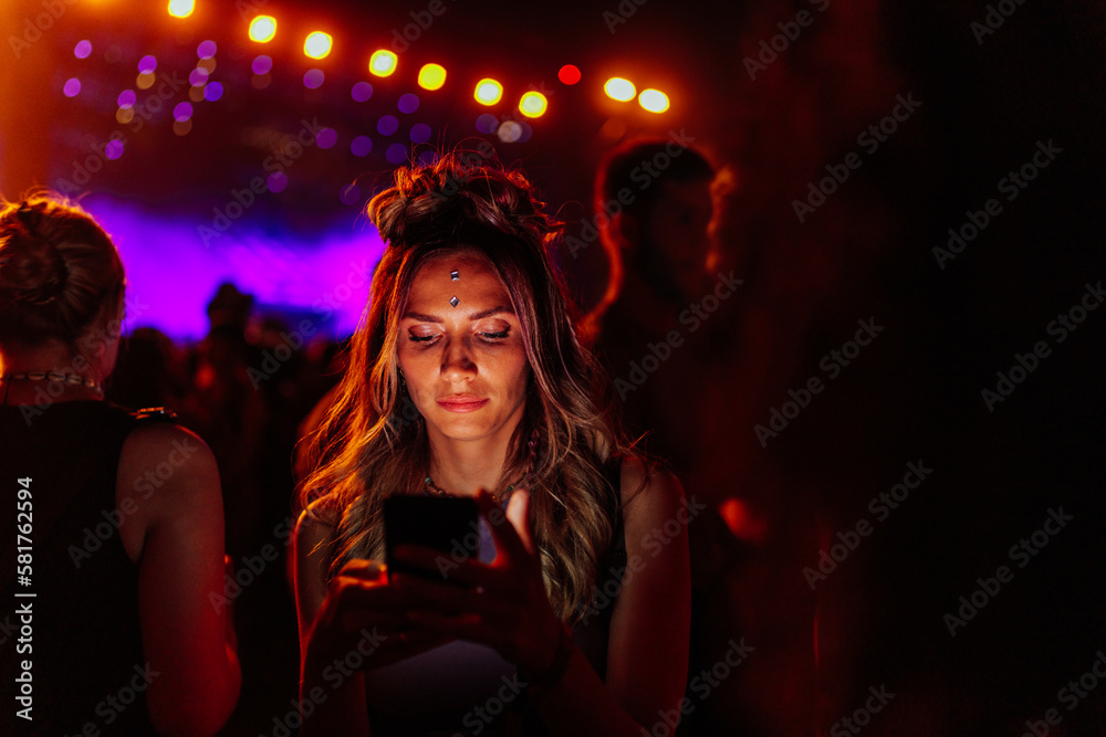 Caucasian woman using smartphone at concert