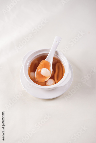 luxury traditional ice cold longan peach gum sea coconut sweet soup in white bowl on wood background asian dessert fresh fruit halal menu