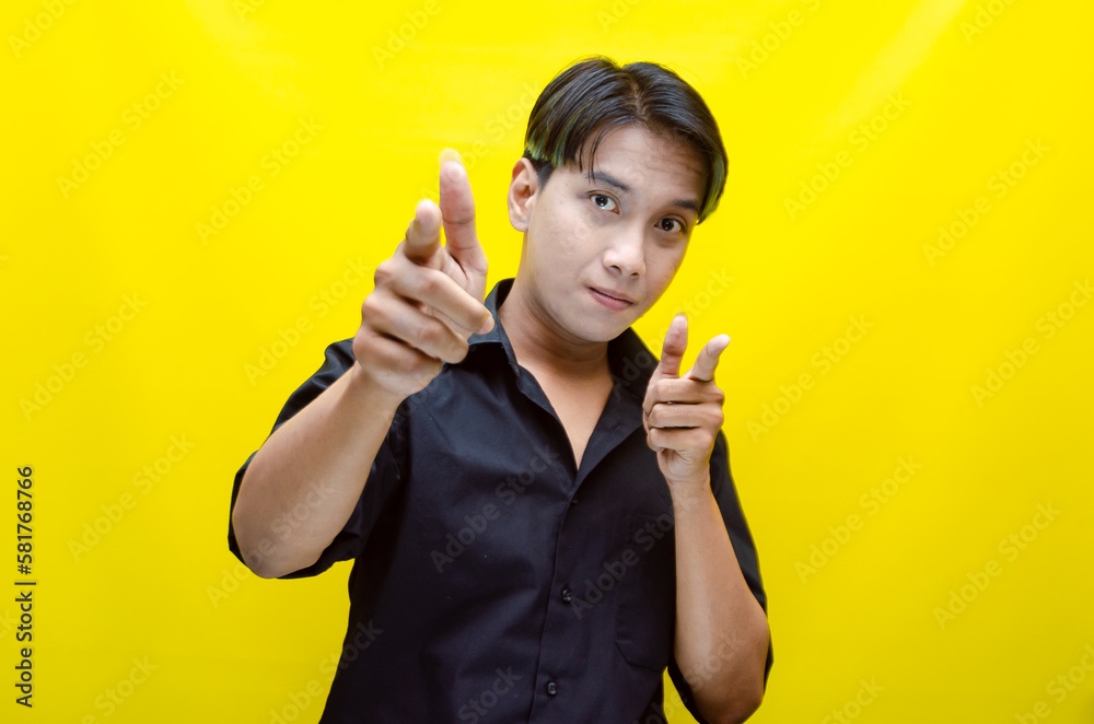 portrait of happy attractive young asian man in peek a boo blue hair with black shirt pointing, promoting and advertising something good. best for model advertisment. portrait of happy attractive young asian man in peek a boo blue hair with black shirt pointing, promoting and advertising something good. best for model advertisment.