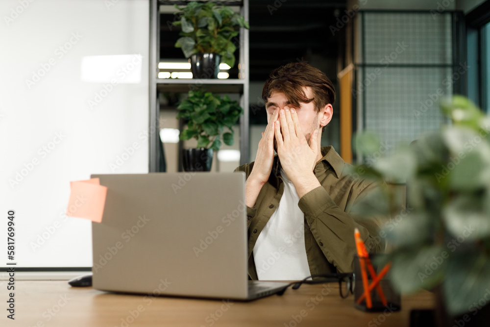 Tired young man feel pain eyestrain holding glasses rubbing dry irritated eyes fatigued from computer work, stressed man suffer from headache bad vision sight problem Tired young man feel pain eyestrain holding glasses rubbing dry irritated eyes fatigued from computer work, stressed man suffer from headache bad vision sight problem