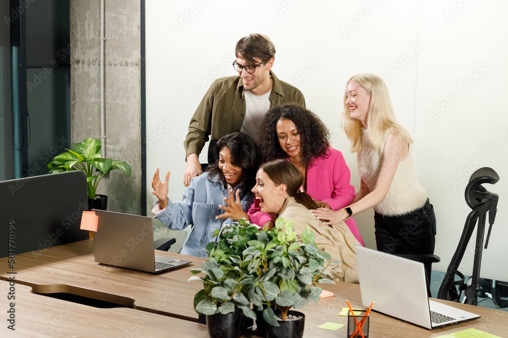 Group of creative people wearing casual shirts, being very happy and success on their jobs or projects while looking at laptop in workplace. Working and Business Concept Group of creative people wearing casual shirts, being very happy and success on their jobs or projects while looking at laptop in workplace. Working and Business Concept