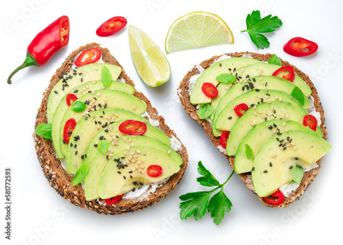 Avocado toasts - bread with avocado slices, pieces of chilli pepper and black sesame isolated on white background.