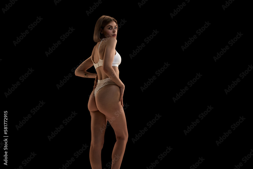 Charming girl with blonde hair. Portrait of young slim beautiful girl wearing white underwear posing over black background. Charming girl with blonde hair. Portrait of young slim beautiful girl wearing white underwear posing over black background.