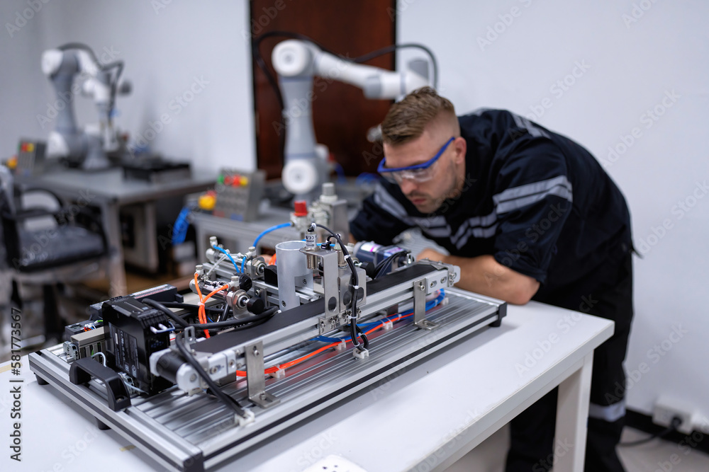 Engineer sitting in robot fabrication room quality checking electronic control board engineering Engineer sitting in robot fabrication room quality checking electronic control board engineering