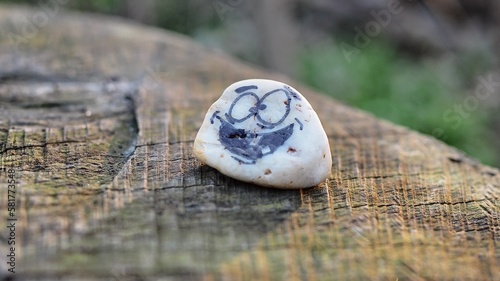 close up of a crazy smiling stone on a wooden surface