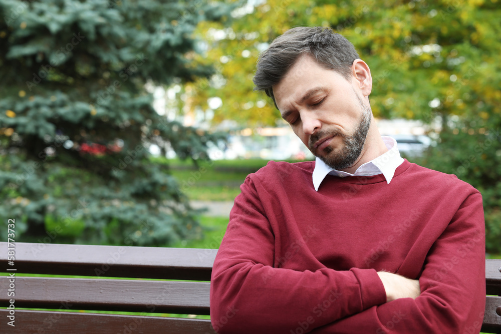 Tired man sleeping on bench in beautiful green park. Space for text Tired man sleeping on bench in beautiful green park. Space for text