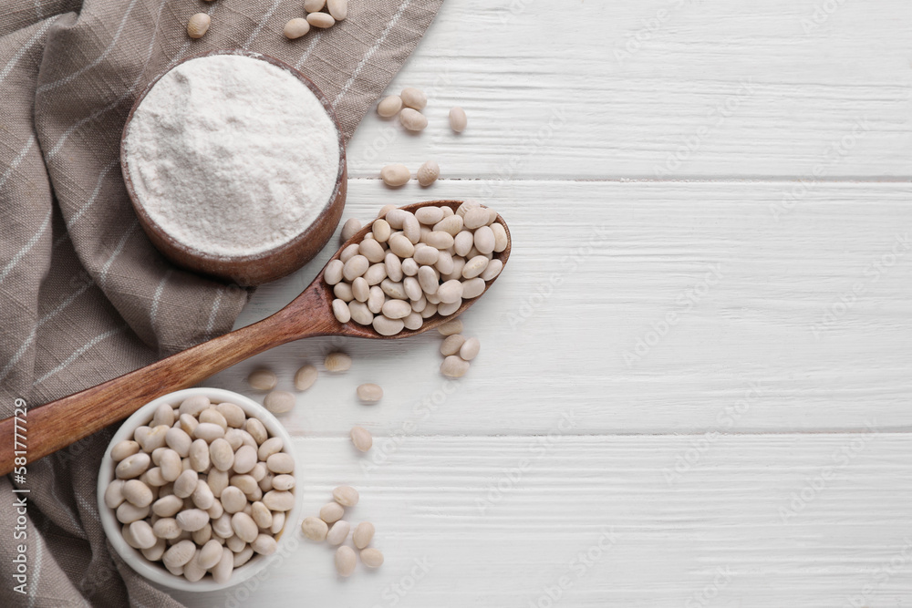 Fototapeta premium Kidney bean flour and seeds on white wooden table, flat lay. Space for text