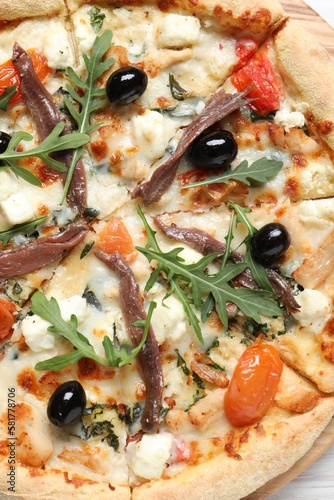 Tasty pizza with anchovies, arugula and olives, top view