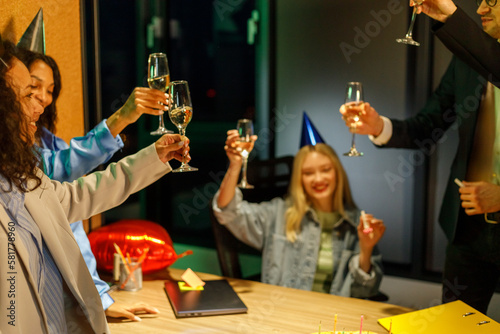 Multiracial young creative people are celebrating holiday in modern office. Group of young business people are drinking champagne in coworking © AvokadoStudio