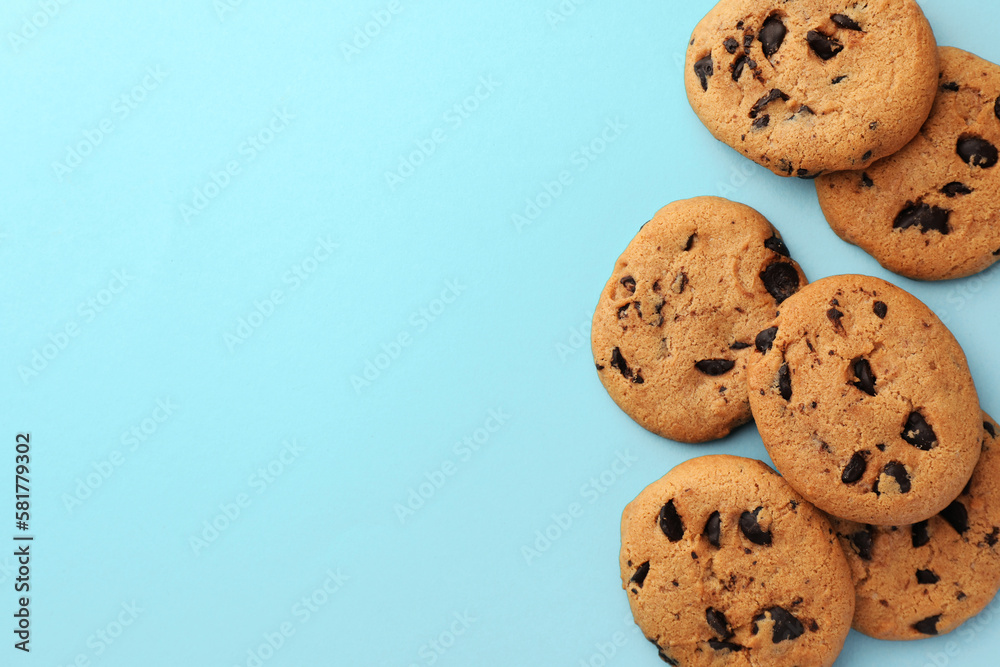 Many delicious chocolate chip cookies on light blue background, flat lay. Space for text Many delicious chocolate chip cookies on light blue background, flat lay. Space for text