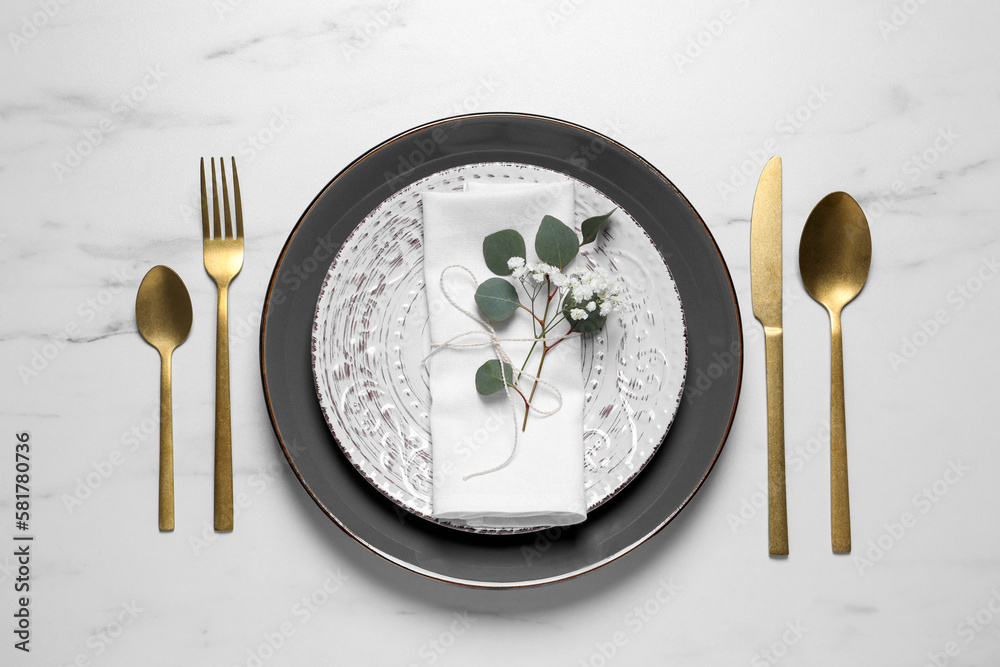 Stylish table setting with cutlery, flower and eucalyptus leaves, flat lay Stylish table setting with cutlery, flower and eucalyptus leaves, flat lay