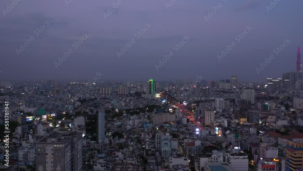 custom made wallpaper toronto digitalHo Chi Minh City, Vietnam evening featuring canal, landmark building and view over rooftops to urban sprawl and main road under lights. Aerial crane shot