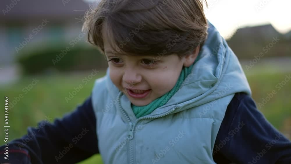 One happy young boy running outside. Child closeup face runs in slow motion outdoors at park. Happiness childhood lifestyle concept One happy young boy running outside. Child closeup face runs in slow motion outdoors at park. Happiness childhood lifestyle concept