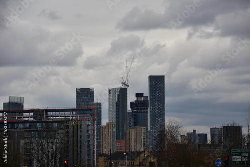 City skyline view with modern skyscrapers and construction work. Manchester city centre on a grey cloudy day. 