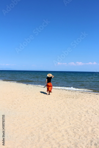 Woman walking alone on beach, Aegean Sea, Greece