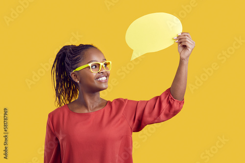 Studio shot of a cheerful black female school teacher in glasses showing a mock up speech bubble card sharing with students interesting information, feedback, idea, thought, or useful English phrase