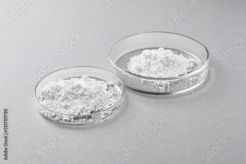 Petri dishes with calcium carbonate powder on light grey table