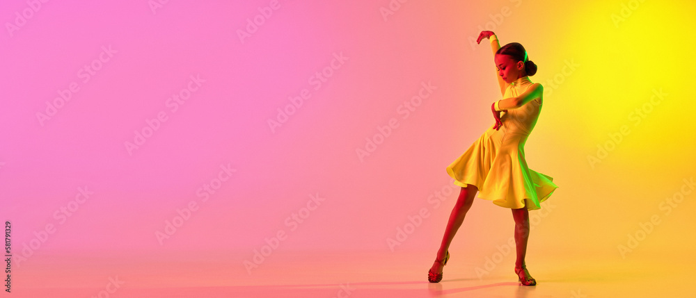 Elegant little girl in adorable stage outfit, dress dancing ballroom dance over gradient pink-yellow background in neon light filter. Concept of beauty, professional dances, skills - obrazy, fototapety, plakaty 