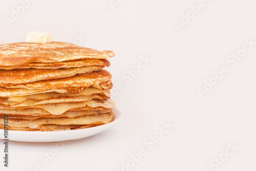 Staple of yeast fluffy pancakes with butter. Spring holiday Traditional Russian Shrovetide Maslenitsa week or pancake tuesday holiday. american crepes isolated on white gray background. side view