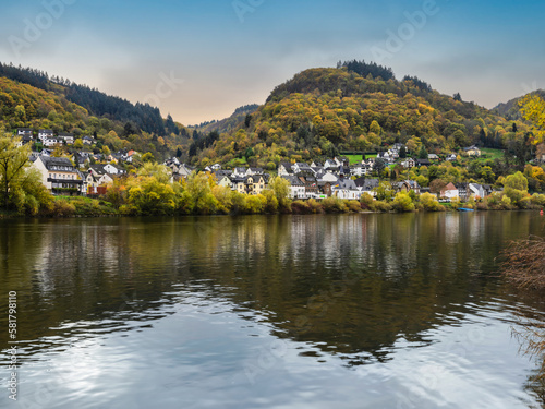 Sehl village, colourful trees during autumn and reflection on Moselle river in Cochem-Zell district, Germany