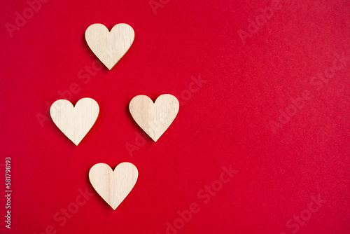 Four wooden hearts placed nicely on viva magenta background. Flat lay copy space.