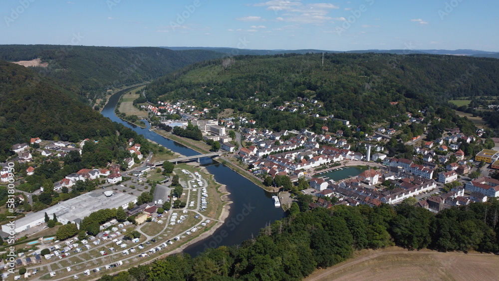 Fototapeta premium Aerial drone view of the small German village called Bad Karlshafen. Old white European buildings in a touristy town on the river Wezer.