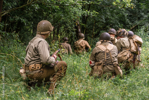 Konstfotografi Historical reeneactors dressed As  american  Infantry Soldier during  World War II  patrol the forest