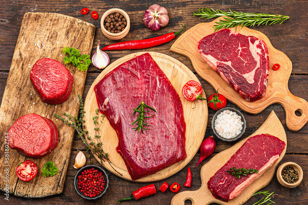 Set of various steaks with spices. Cuts includes ribeye, eye round