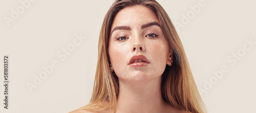 Studio beauty portrait of young natural woman with freckles on her face. Ideal, delicate makeup with lipstick.