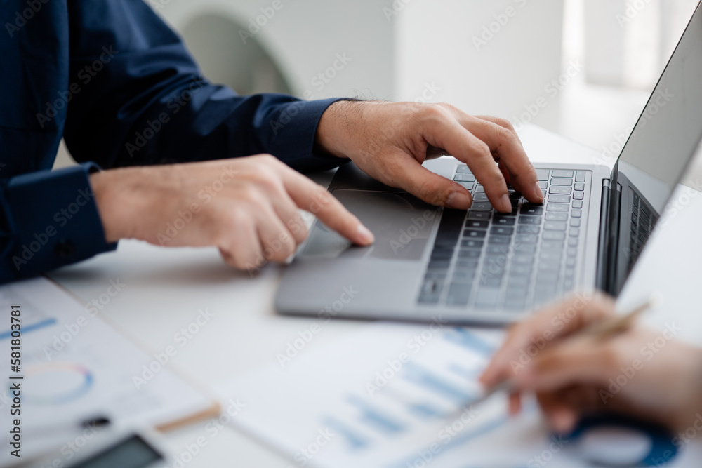 Person typing on laptop keyboard, businessman working on laptop, he is typing messages to colleagues and making financial information sheet to sum up the meeting. Person typing on laptop keyboard, businessman working on laptop, he is typing messages to colleagues and making financial information sheet to sum up the meeting.