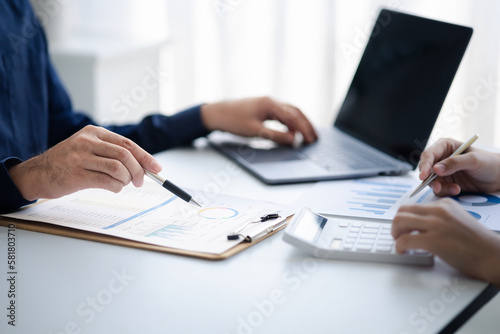 Group business people are brainstorming together and reviewing the company financial documents that the finance department has summarized, they are business partners. Business administration concept. © PhotosD