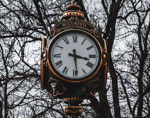 The vintage street clock stands tall and proud, a testament to a bygone era. Its ornate design and intricate details evoke a sense of nostalgia and charm. 