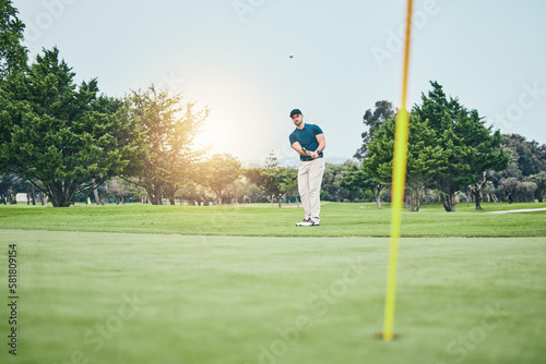 Grass, golf hole and man with golfing club on course for game, practice and training for competition. Professional golfer, sports and male athlete hit ball with club for winning, score or tee stroke