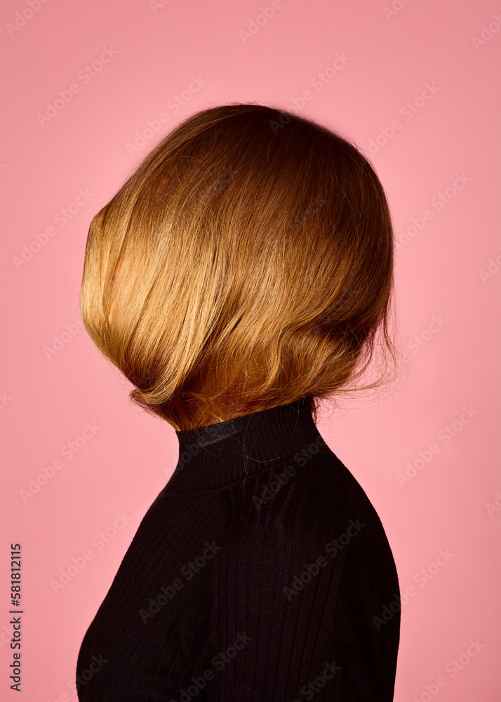 a woman with long, curly hair posing on a pink background a woman with long, curly hair posing on a pink background
