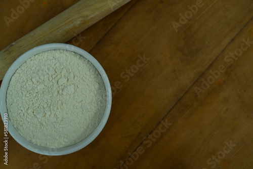 A bowl of flour on a wooden table, World Flour day and cooking concept Selective focus photo
