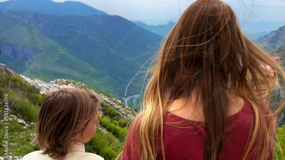 A young woman and her son observe beautiful canyon of the Cijevna river on a way to the Grlo Sokolovo, a famous canyon at the Montenegro-Albania border. Travel to Montenegro concept A young woman and her son observe beautiful canyon of the Cijevna river on a way to the Grlo Sokolovo, a famous canyon at the Montenegro-Albania border. Travel to Montenegro concept