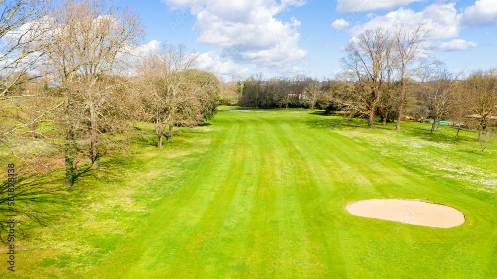 Aerial view of an empty golf course with green hills and sand bunkers. The sports club is empty and nobody is playing. Sports concept. Aerial view of an empty golf course with green hills and sand bunkers. The sports club is empty and nobody is playing. Sports concept.