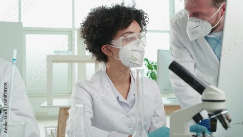 female scientist in protective clothing works in a scientific laboratory.