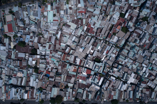 Ho Chi Minh City, Vietnam, top down aerial view on a sunny day featuring rooftops of densely populated crowded residential area.