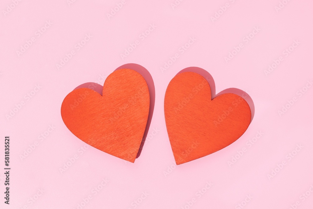 Two Wooden red heart shape isolated on pink background