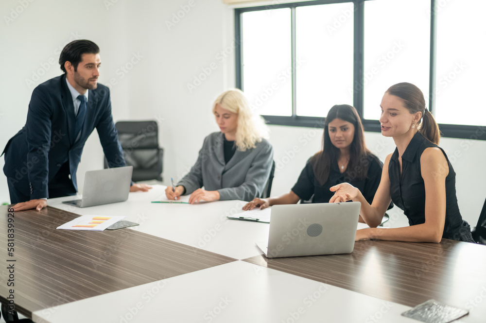 Group of coworkers in formal wear sitting at table in conference room. Business meeting team in office