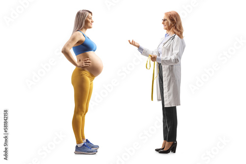 Female doctor talking to a pregnant woman in sportswear
