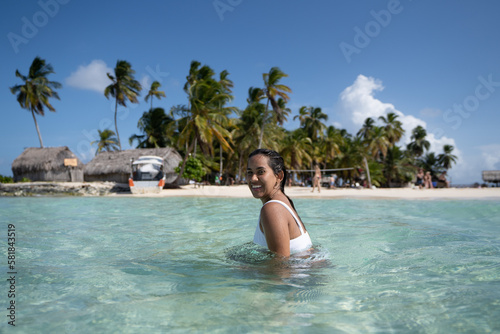 Beautiful tan Colombian women in crystal Caribbean sea water in San Blas Palm tree Islands, Panama © Calum